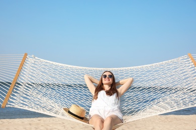 Photo of Young woman relaxing in hammock on beach