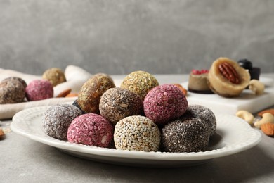 Photo of Different delicious vegan candy balls on grey table