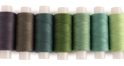 Photo of Set of colorful sewing threads on white background, top view