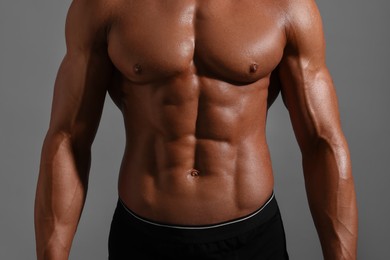 Photo of Young bodybuilder with muscular body on grey background, closeup