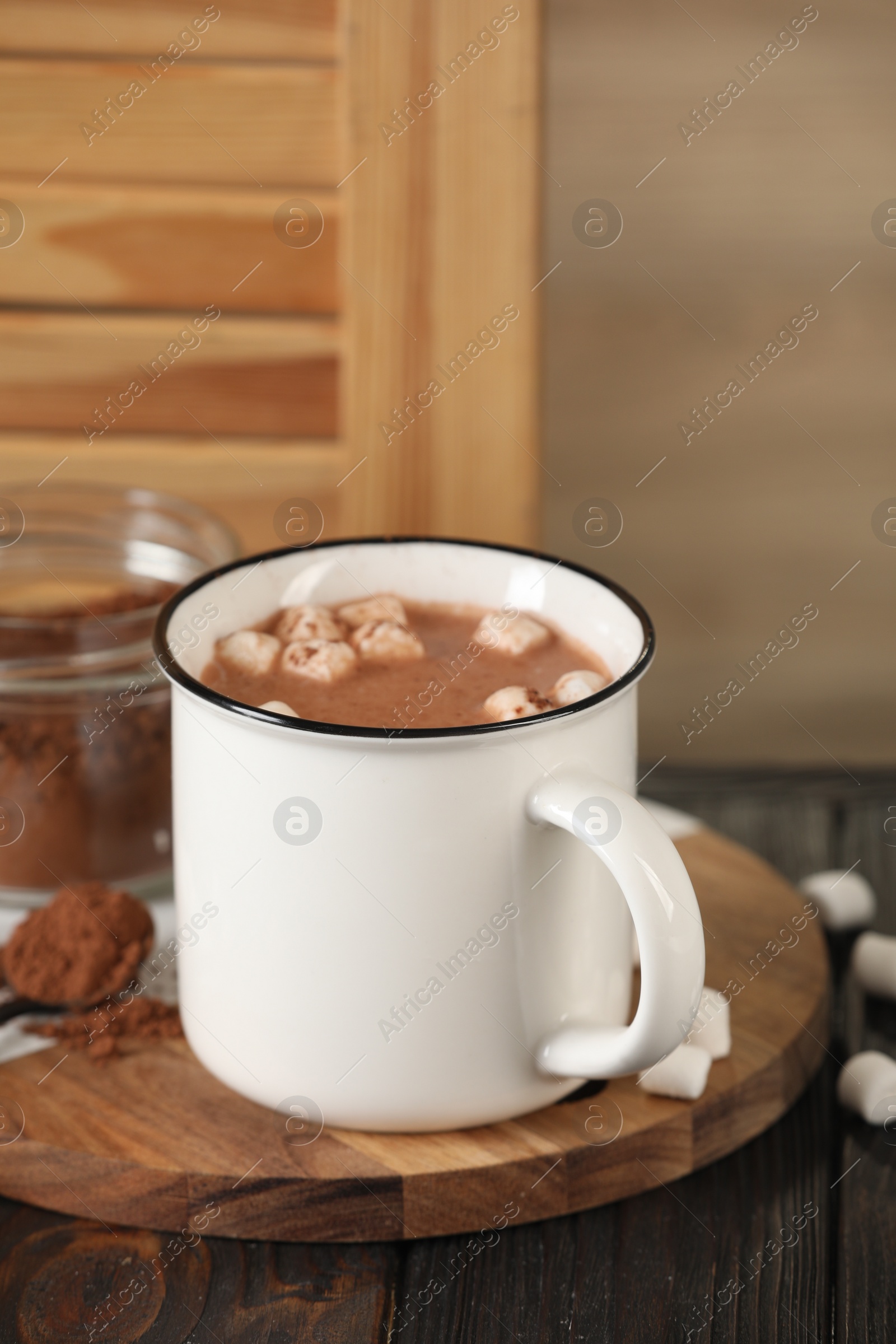Photo of Cup of aromatic hot chocolate with marshmallows and cocoa powder on table, space for text