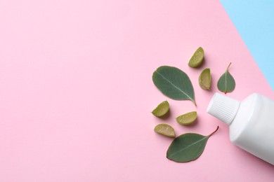 Photo of Blank tube of toothpaste with eucalyptus leaves and aloe on color background, flat lay. Space for text