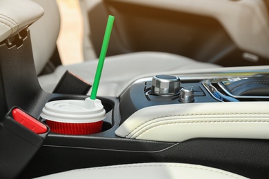 Takeaway paper coffee cup in holder inside car