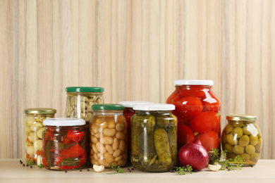 Jars of pickled vegetables on wooden table