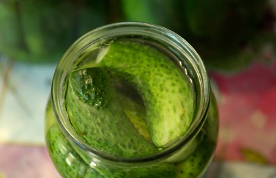 Photo of Pickling jar with fresh cucumbers on table, above view