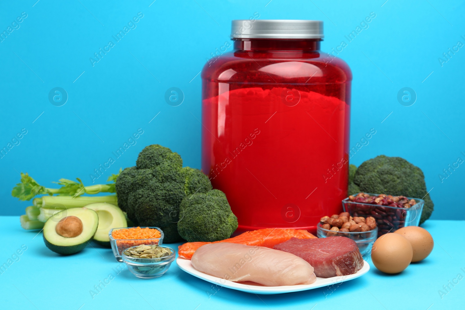 Photo of Set of products rich in amino acids and jar with protein powder on light blue background