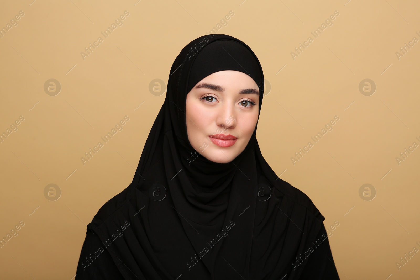 Photo of Portrait of Muslim woman in hijab on beige background