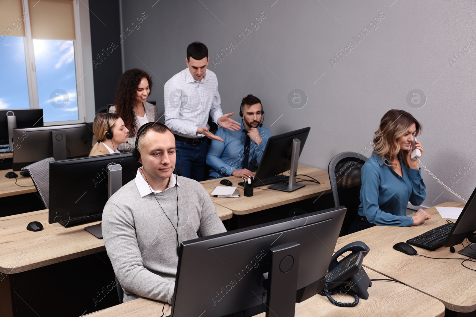 Photo of Call center operators working in modern office