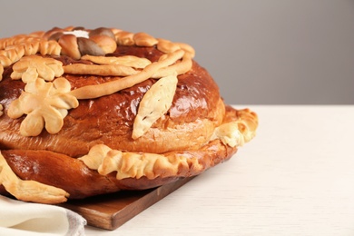 Photo of Korovai on white table, space for text. Ukrainian bread and salt welcoming tradition