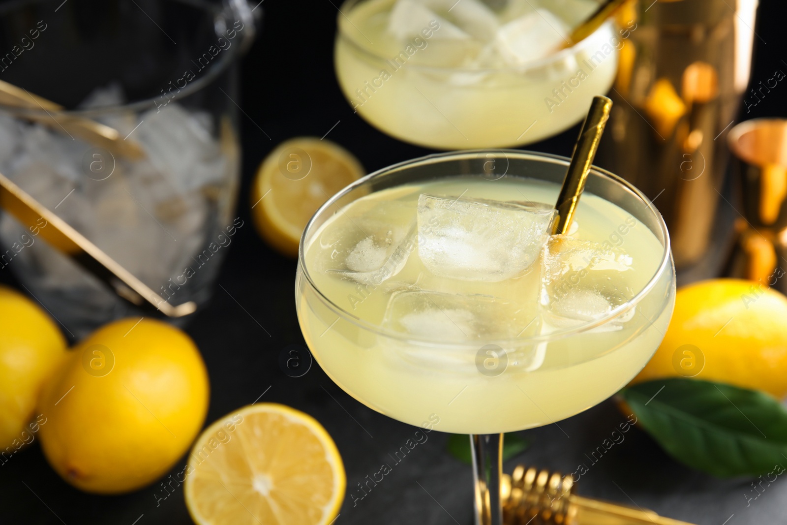 Photo of Delicious bee's knees cocktails and ingredients on black table, closeup