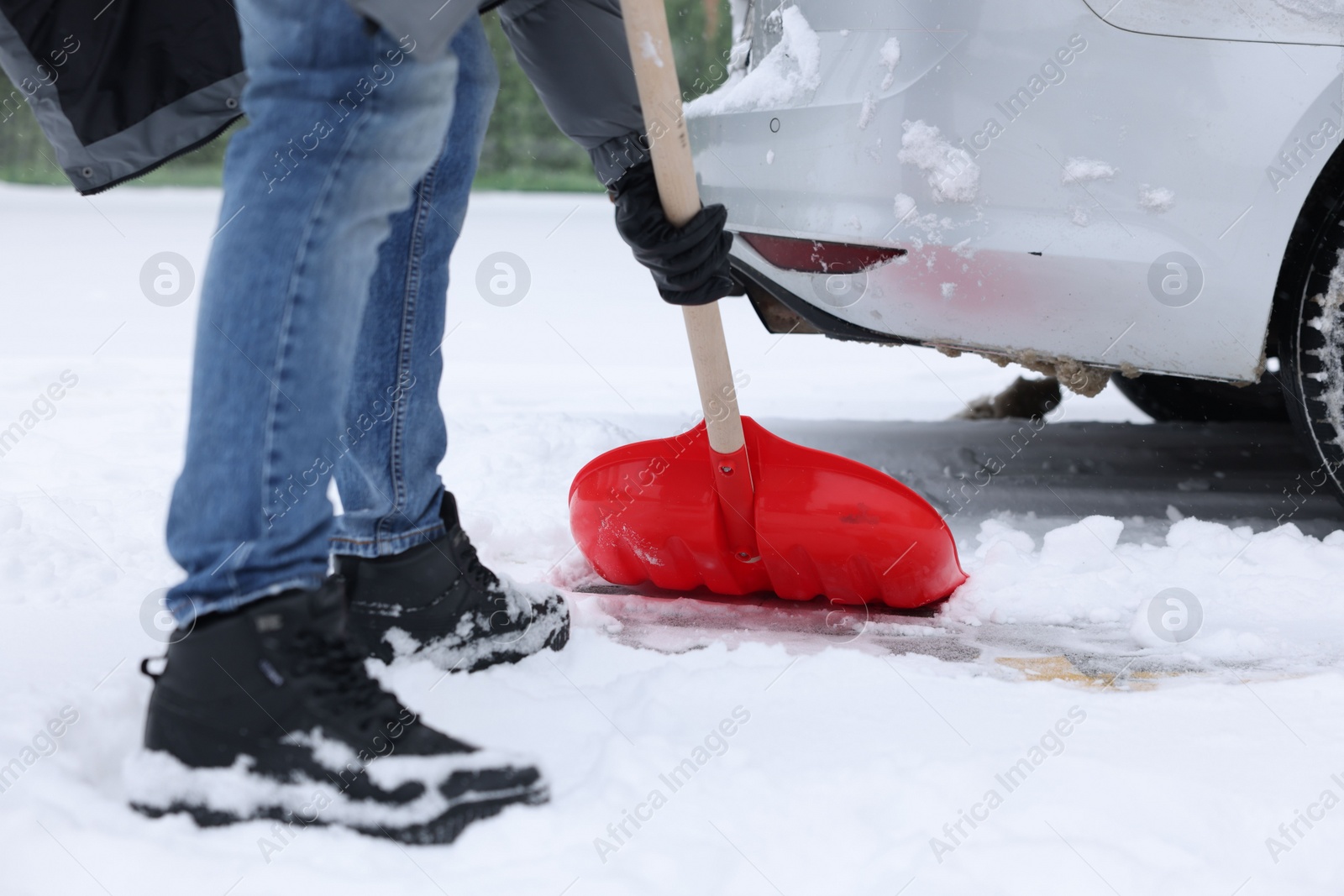 Photo of Man removing snow with shovel near car outdoors, closeup