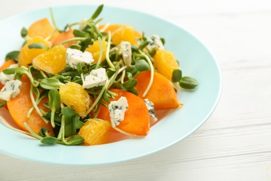 Photo of Delicious persimmon salad served on white table, closeup