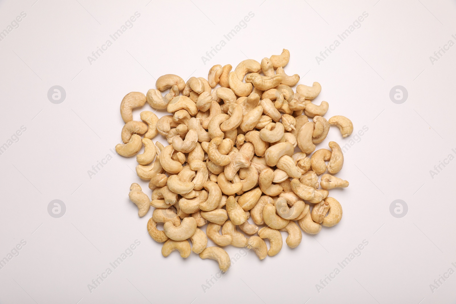 Photo of Pile of tasty cashew nuts on white background, top view