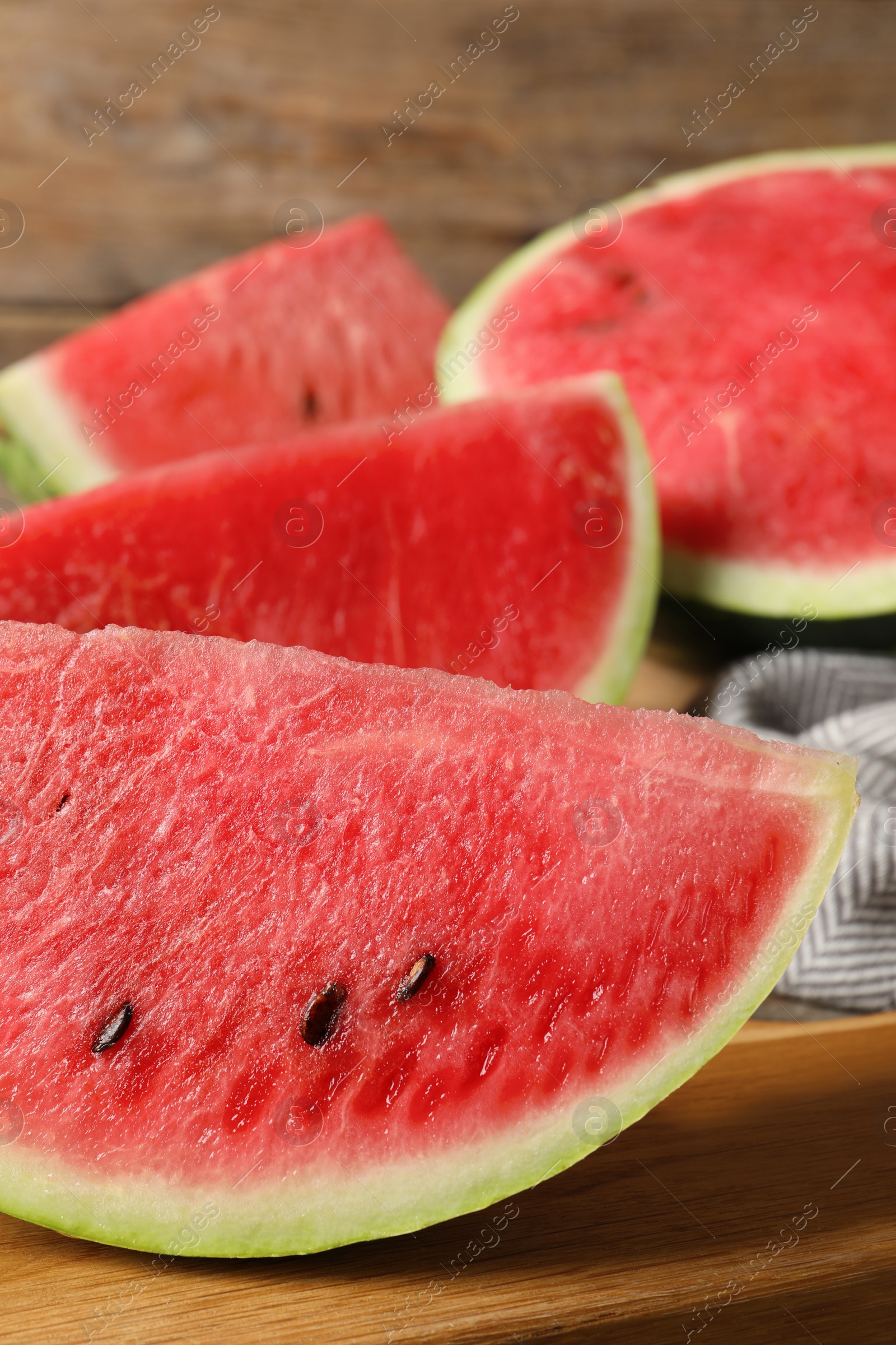 Photo of Delicious fresh watermelon slices on wooden board, closeup