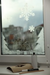 Photo of Beautiful drawing made with artificial snow on window at home. Christmas decor