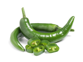 Photo of Cut and whole green hot chili peppers on white background