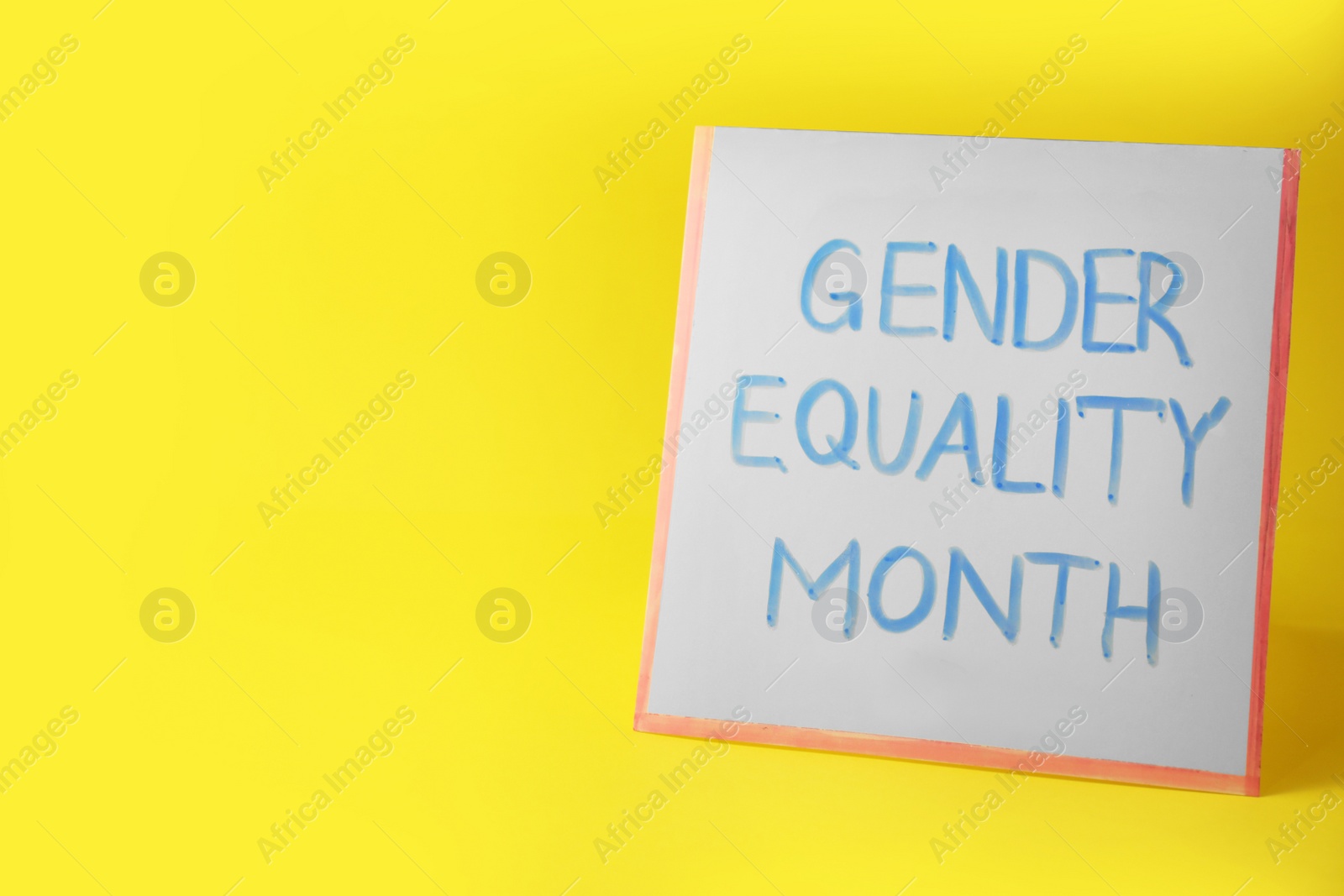 Photo of Card with phrase Gender Equality Month on yellow background, space for text