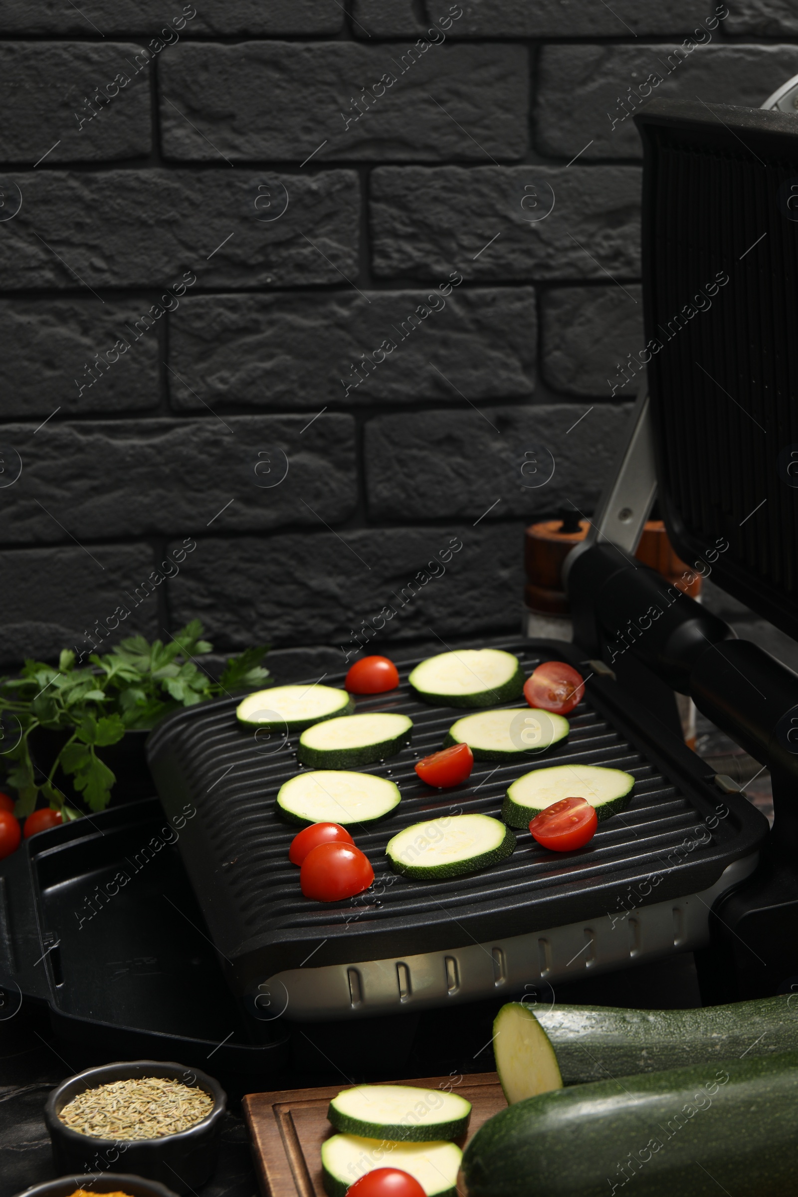 Photo of Electric grill with vegetables on table, closeup