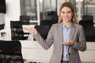 Happy female real estate agent in office