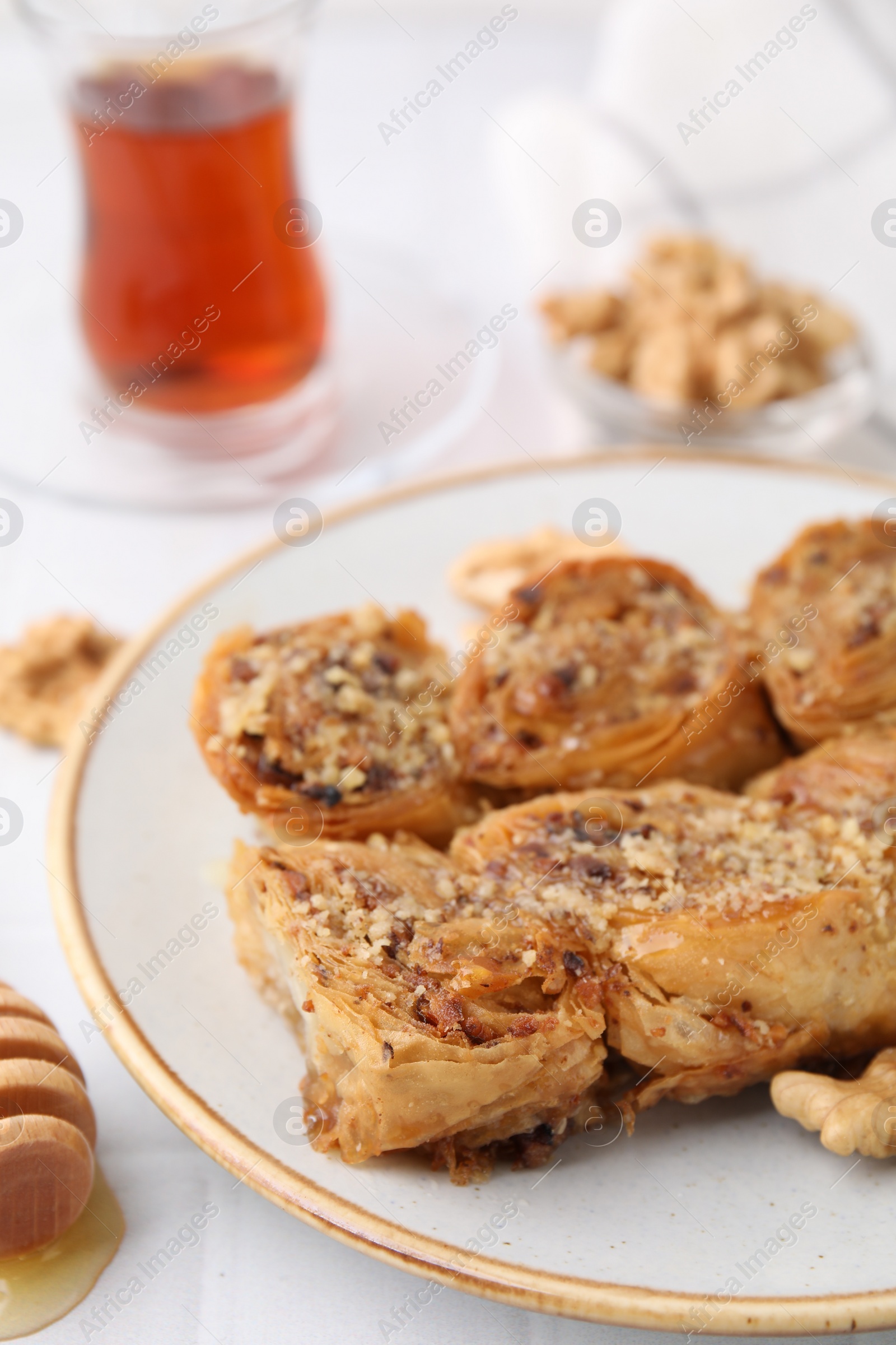 Photo of Eastern sweets. Pieces of tasty baklava on white tiled table, closeup