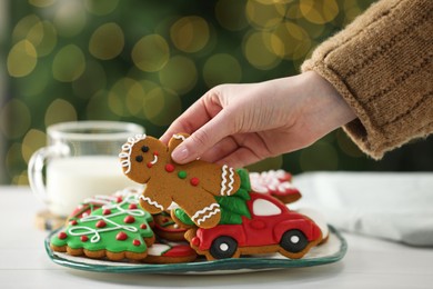 Photo of Woman with decorated Christmas cookies at table, closeup