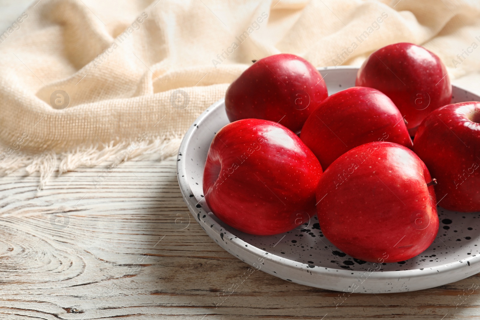 Photo of Plate with ripe red apples on wooden background