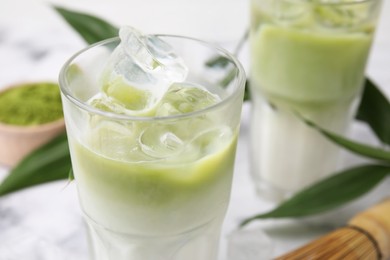 Photo of Glasses of tasty iced matcha latte on table, closeup