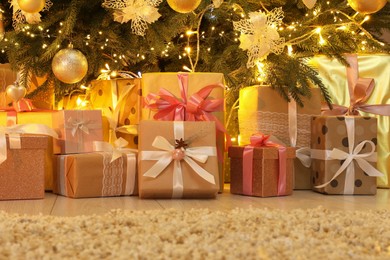 Many gift boxes near decorated Christmas tree at home