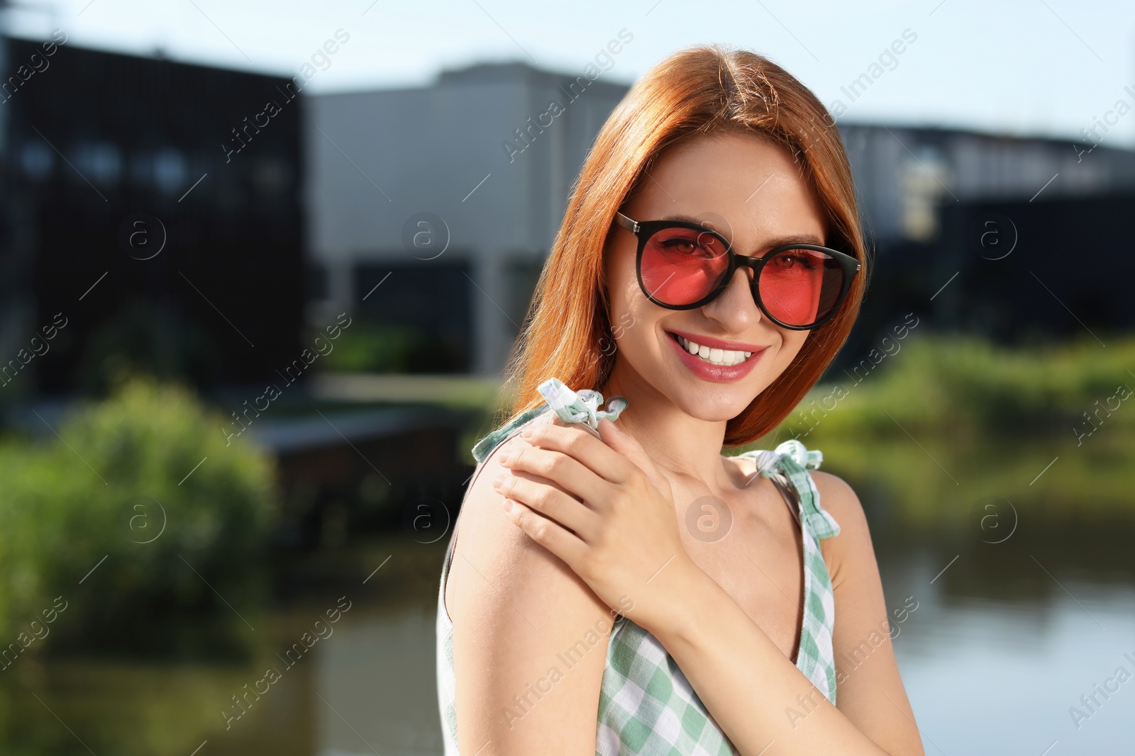 Photo of Beautiful smiling woman in sunglasses near river, space for text