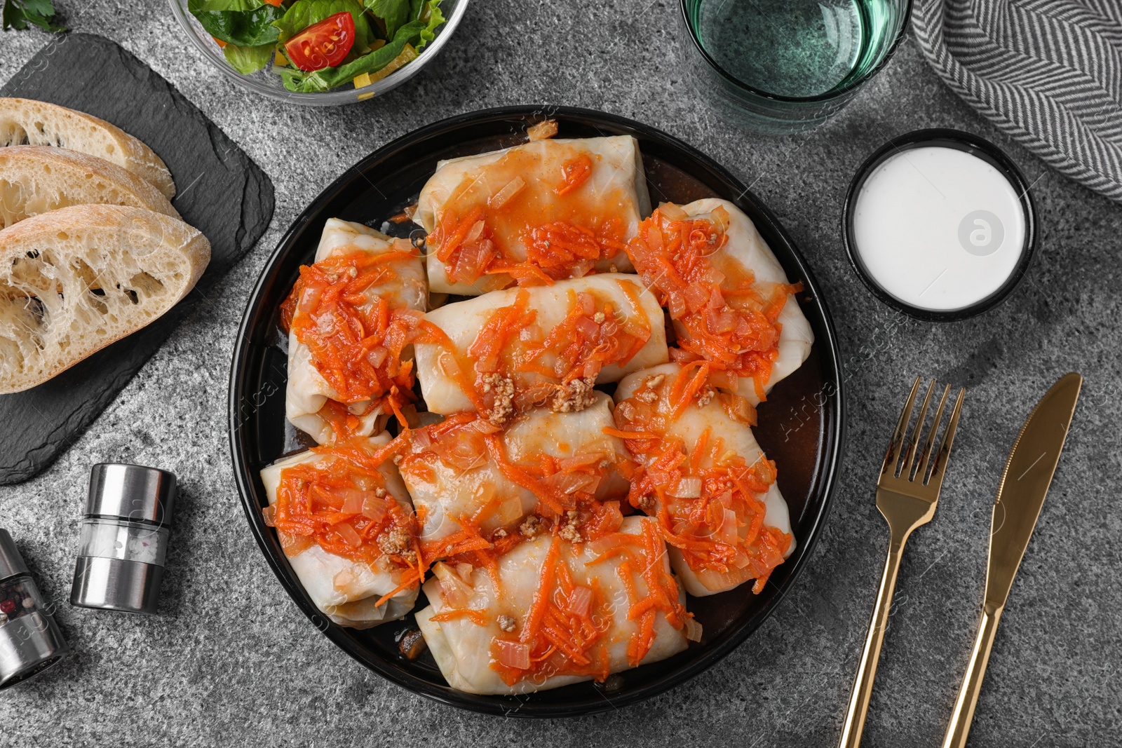 Photo of Delicious cabbage rolls served on grey table, flat lay