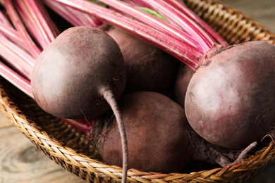 Photo of Raw ripe beets in wicker bowl, closeup