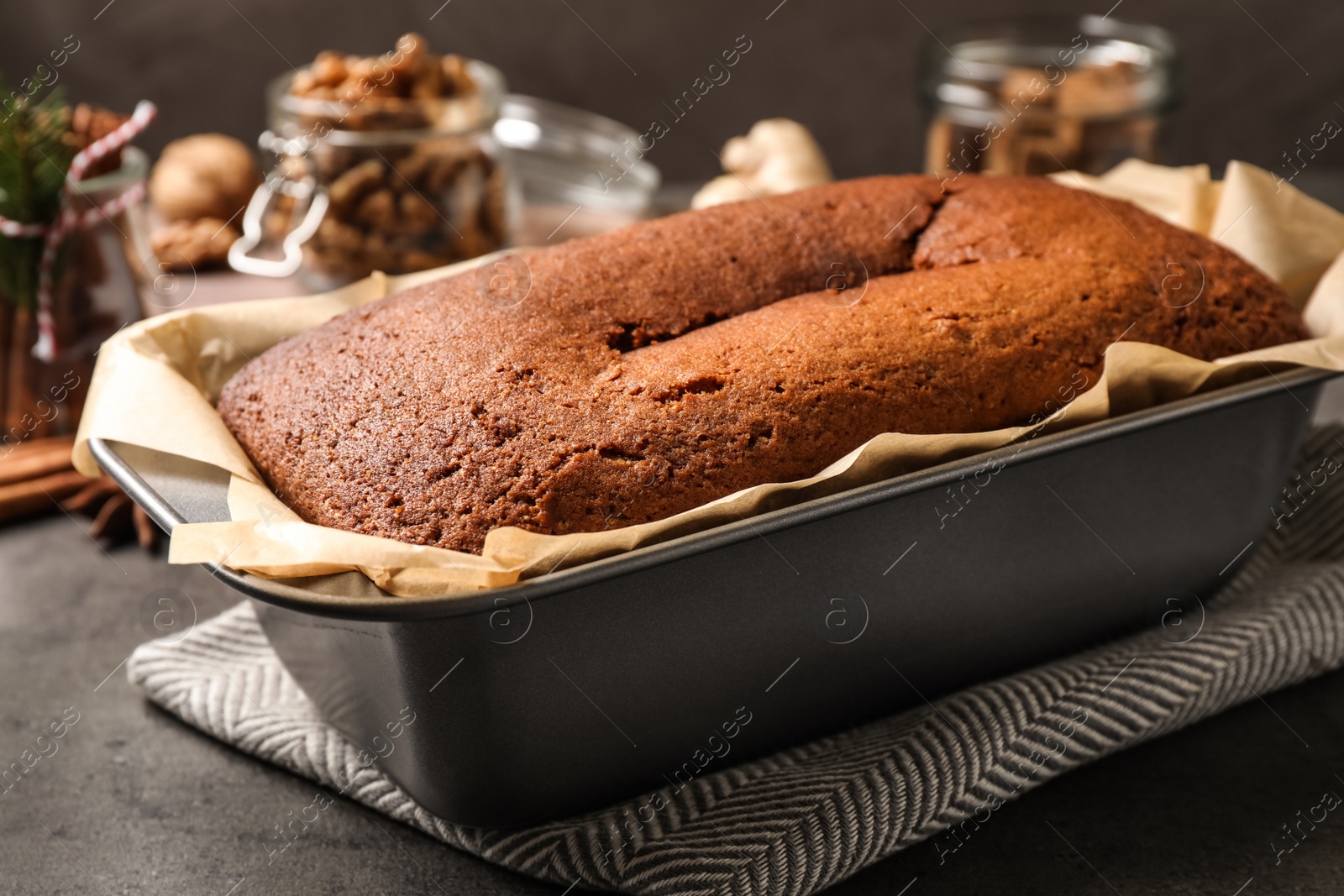 Photo of Delicious gingerbread cake in baking dish on grey table, closeup