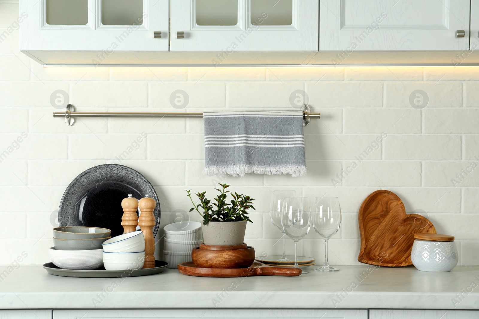 Photo of Set of clean tableware on white countertop in kitchen