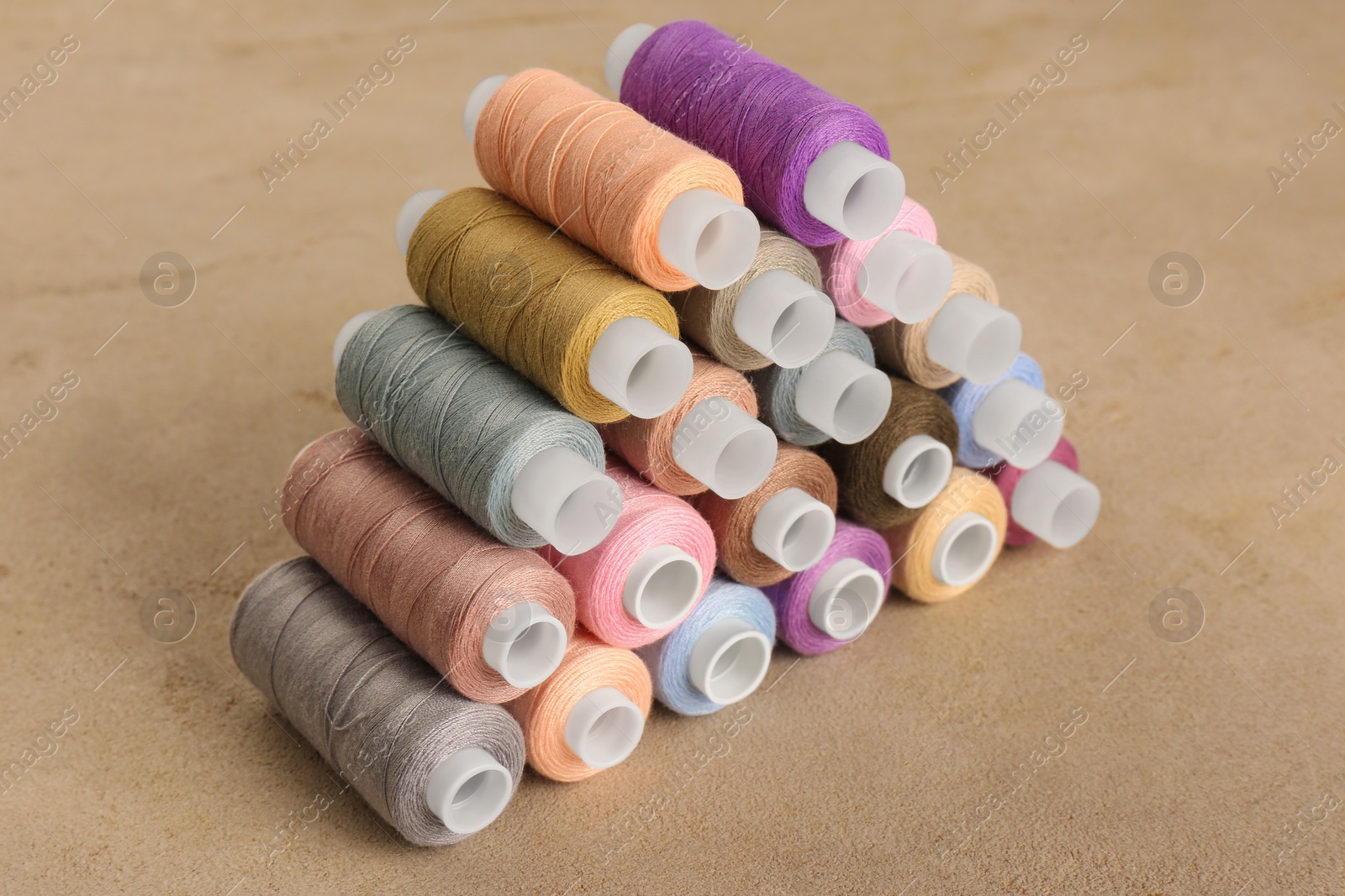 Photo of Set of color sewing threads on grey table