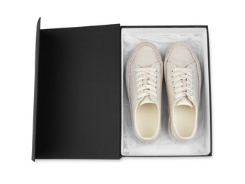 Photo of Pair of stylish sport shoes in black box on white background, top view