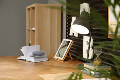 Photo of Comfortable workplace with tablet and wooden table