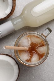 Photo of Mason jar of delicious iced coffee with coconut syrup on light grey table, flat lay