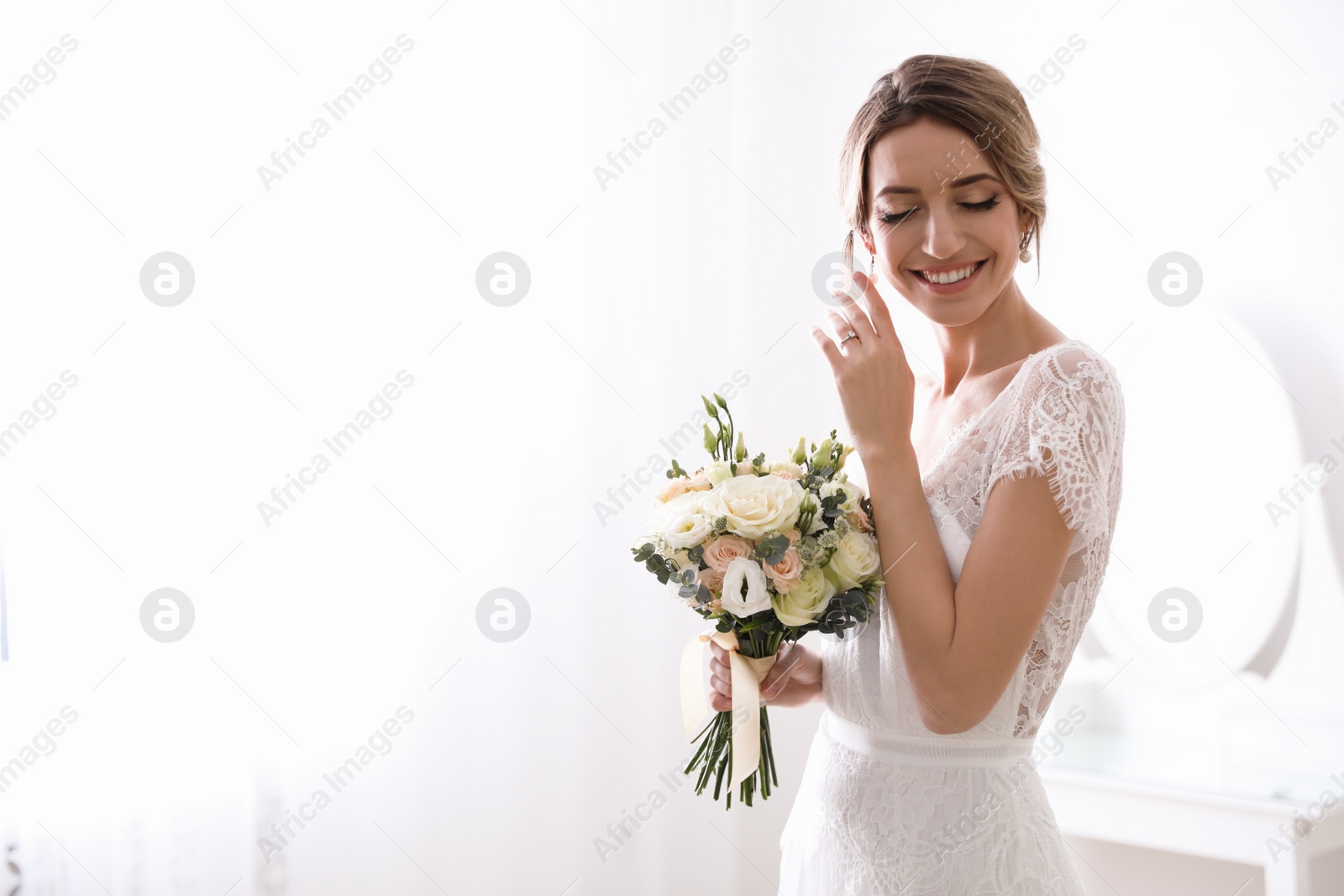 Photo of Bride in beautiful wedding dress with bouquet indoors. Space for text