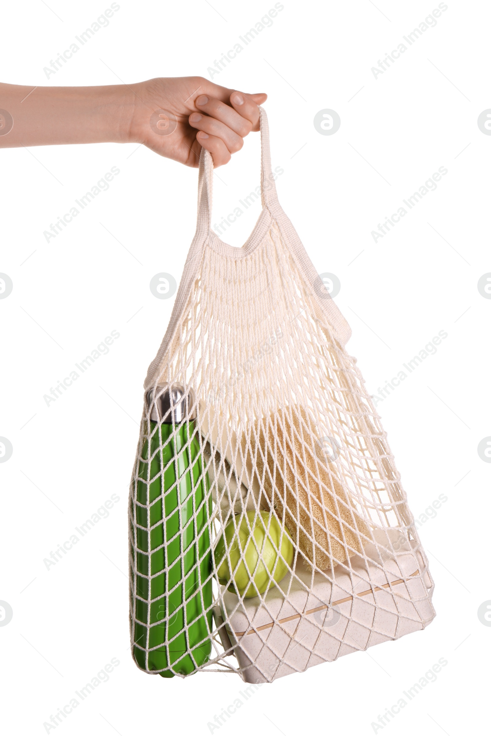 Photo of Woman holding net bag with different items on white background, closeup. Conscious consumption
