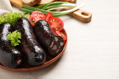 Photo of Tasty blood sausages served on white wooden table, closeup. Space for text