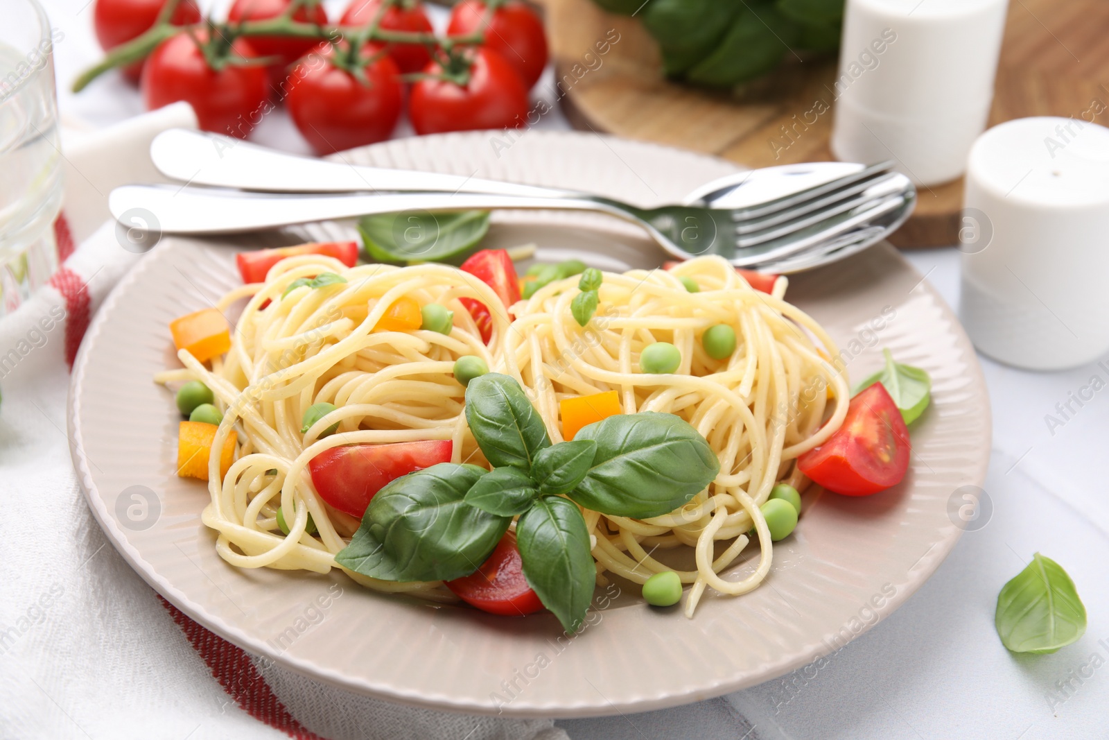 Photo of Plate of delicious pasta primavera served on white table, closeup