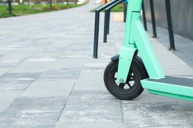 Closeup view of turquoise kick scooter on pavement. Space for text