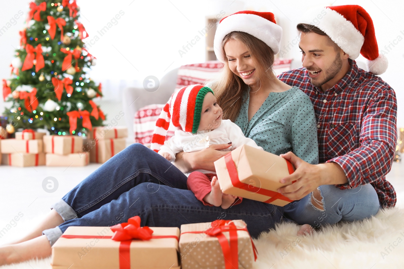 Photo of Happy couple with baby celebrating Christmas together at home