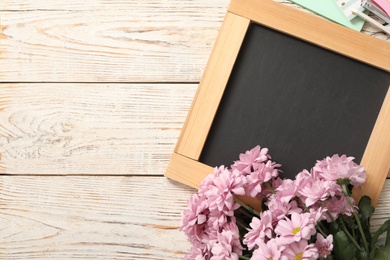 Blackboard, stationery and flowers on white wooden table, flat lay with space for text. Teacher's Day