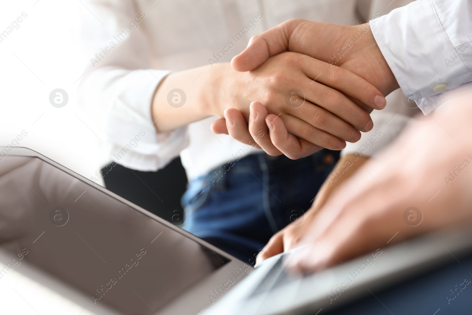 Photo of Business partners shaking hands after meeting, closeup