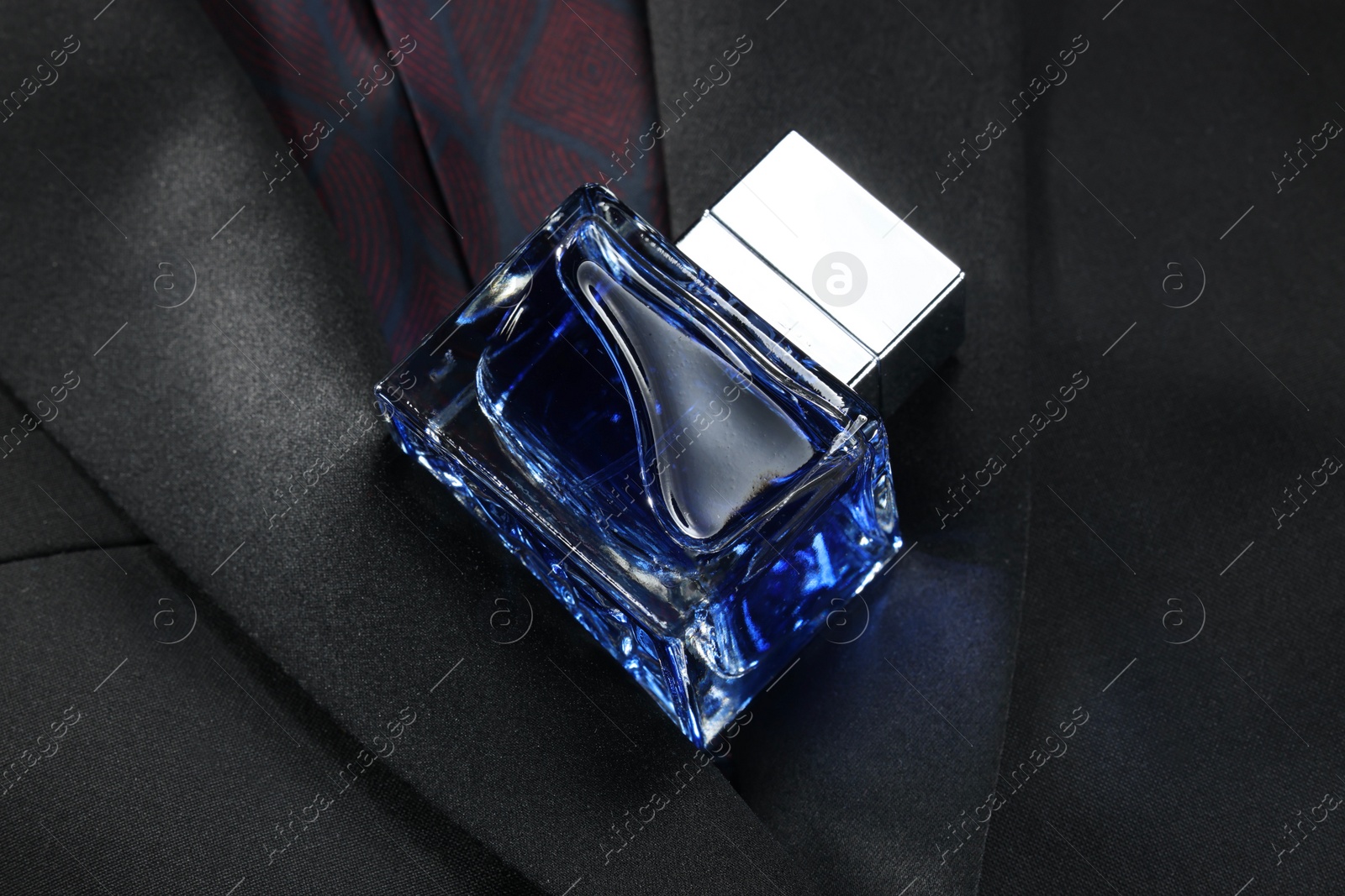 Photo of Luxury men's perfume in bottle on black jacket