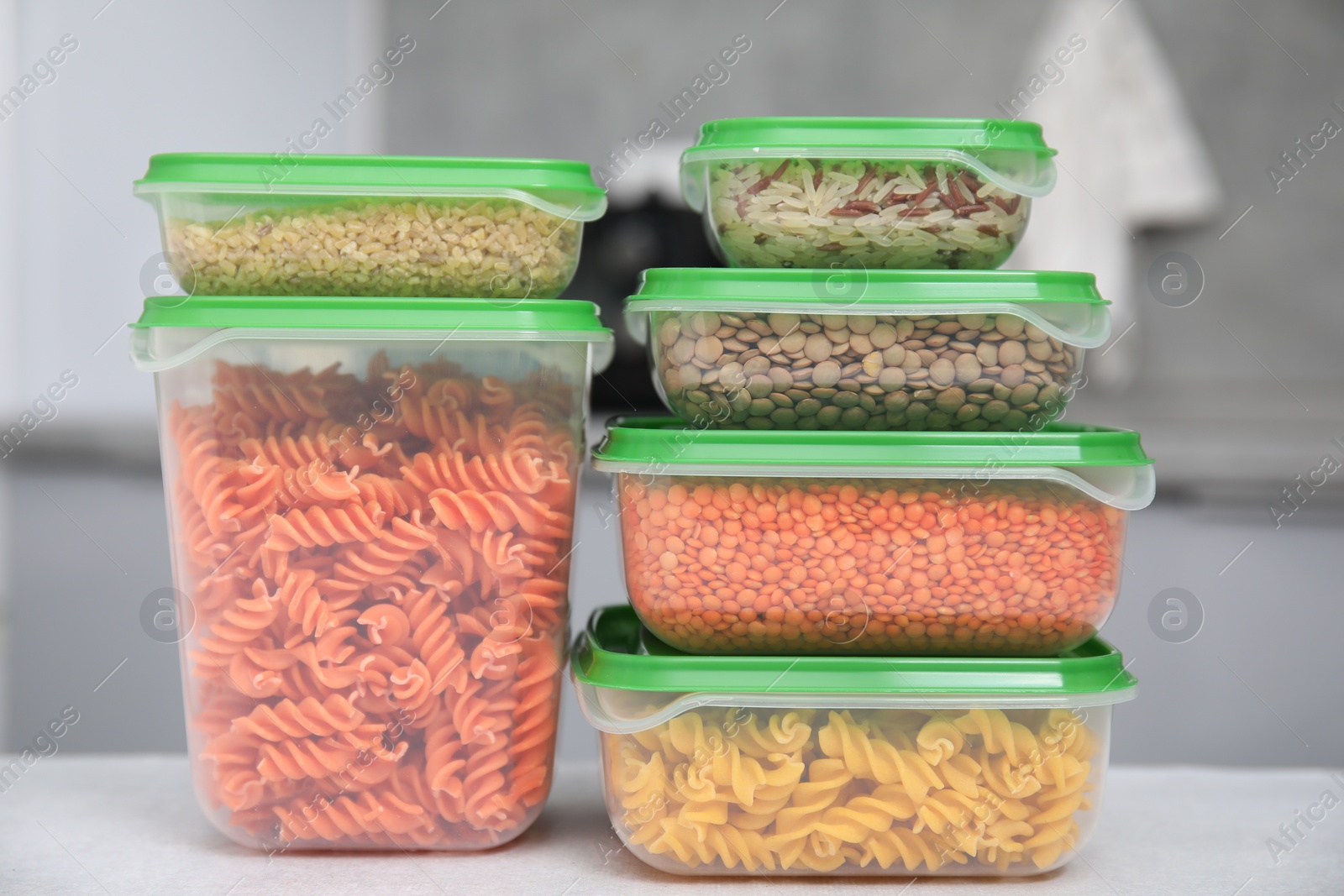 Photo of Plastic containers filled with food products on light table indoors