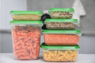 Plastic containers filled with food products on light table indoors