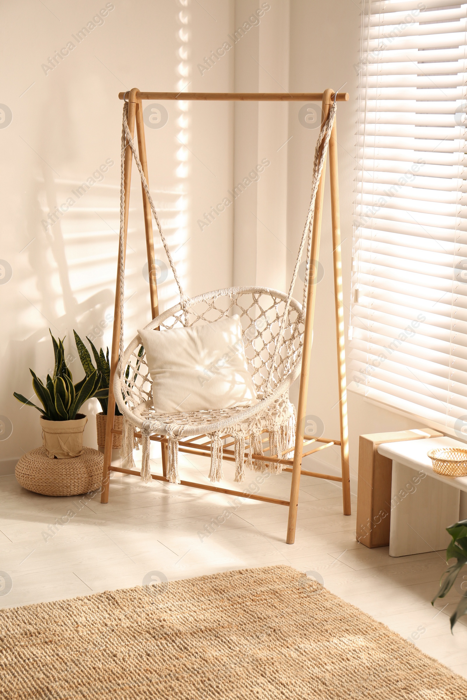 Photo of Comfortable hammock chair in stylish room. Home interior