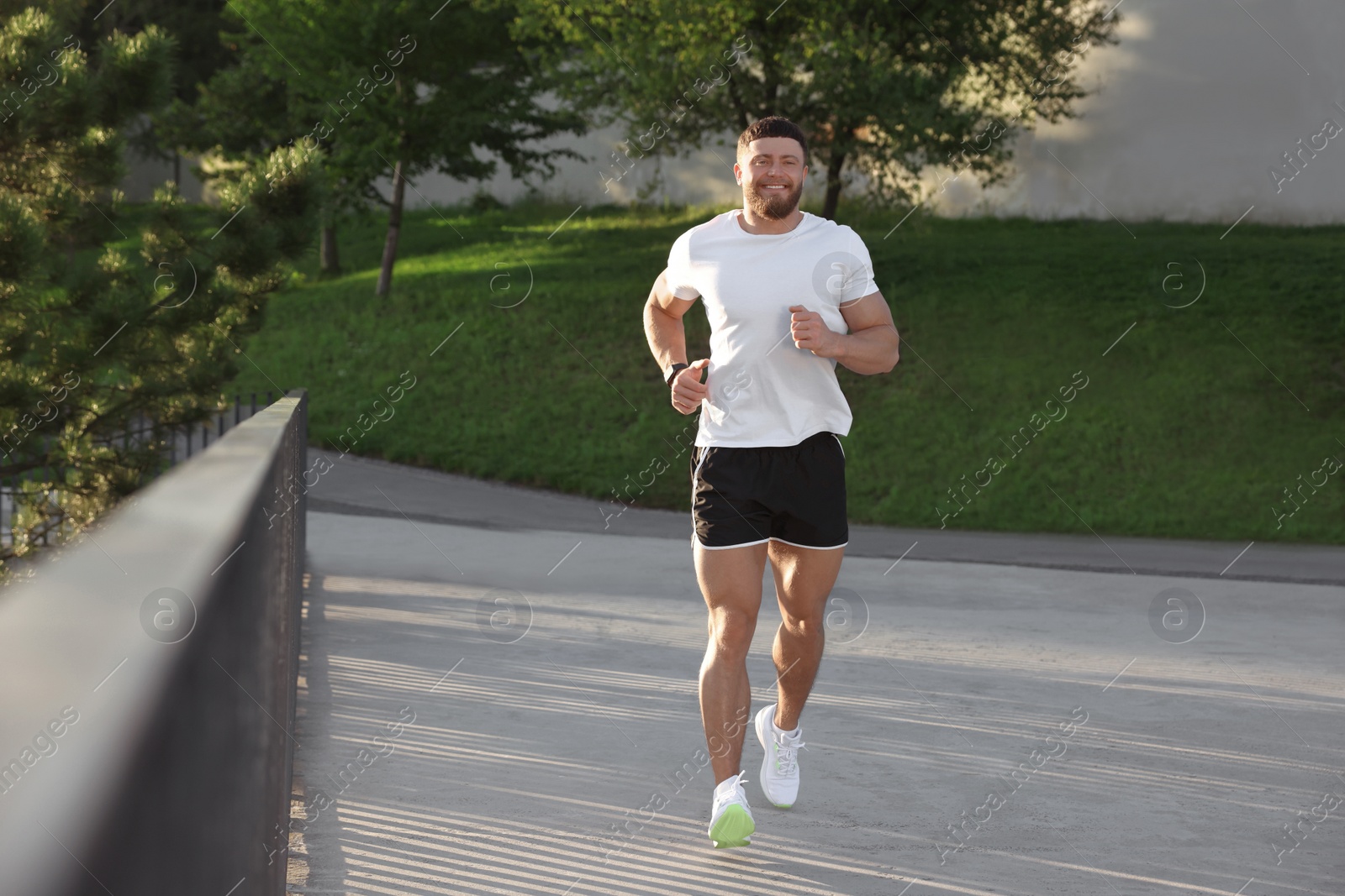 Photo of Smiling man running outdoors on sunny day